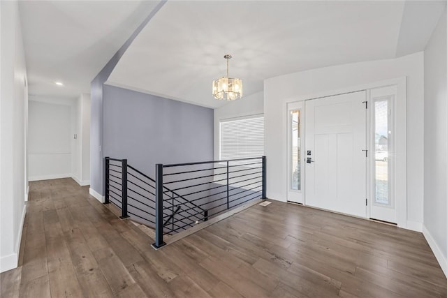 entryway featuring baseboards, an inviting chandelier, and wood finished floors