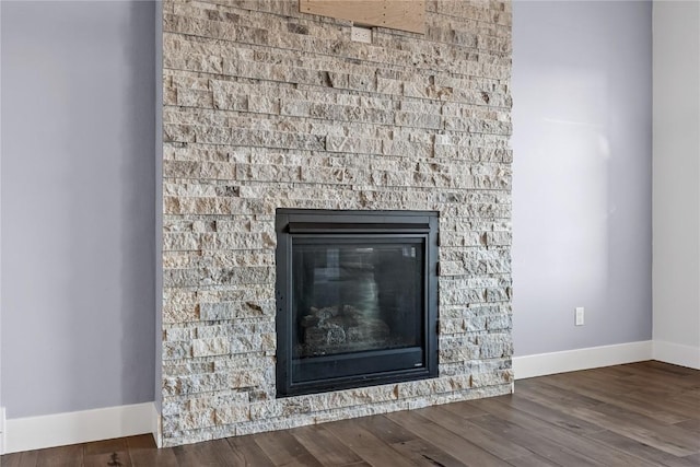 details with baseboards, wood finished floors, and a glass covered fireplace