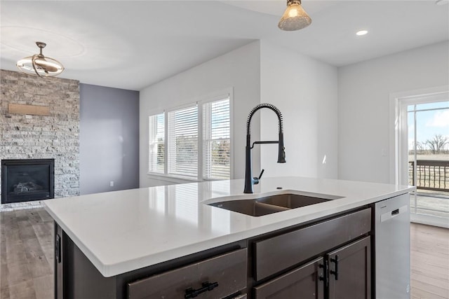 kitchen featuring a wealth of natural light, a sink, an island with sink, and stainless steel dishwasher