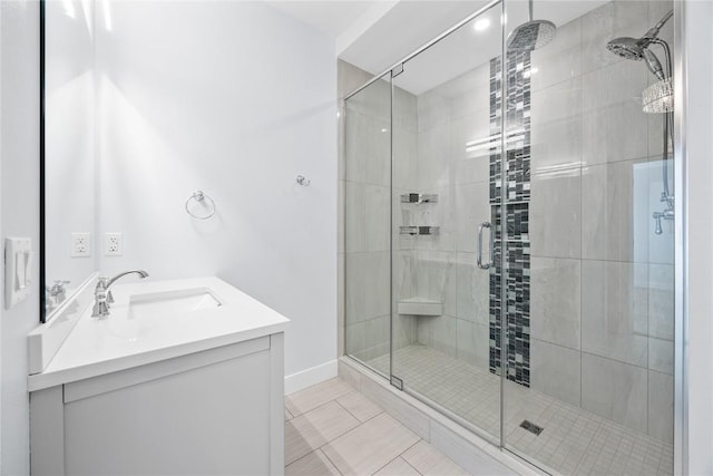 full bath with baseboards, a stall shower, and vanity