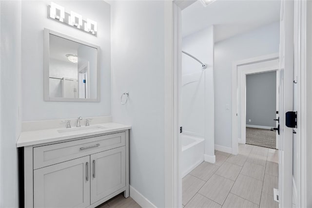 bathroom with shower / washtub combination, vanity, and baseboards