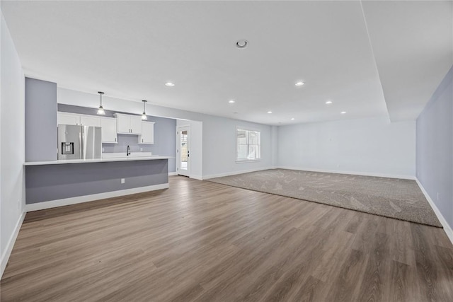 unfurnished living room featuring recessed lighting, baseboards, and wood finished floors