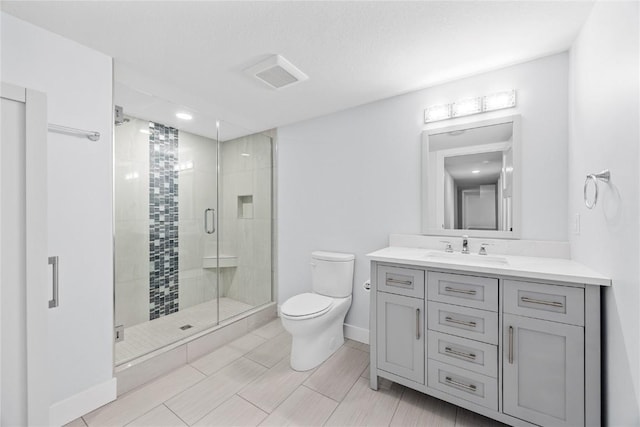 bathroom featuring vanity, visible vents, baseboards, a stall shower, and toilet