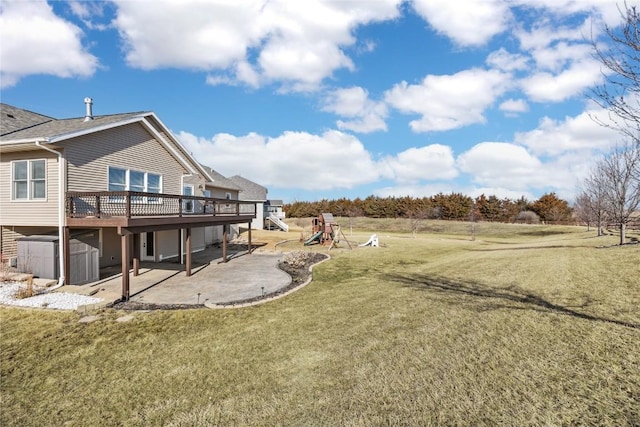 view of yard with a deck, a patio, and a playground