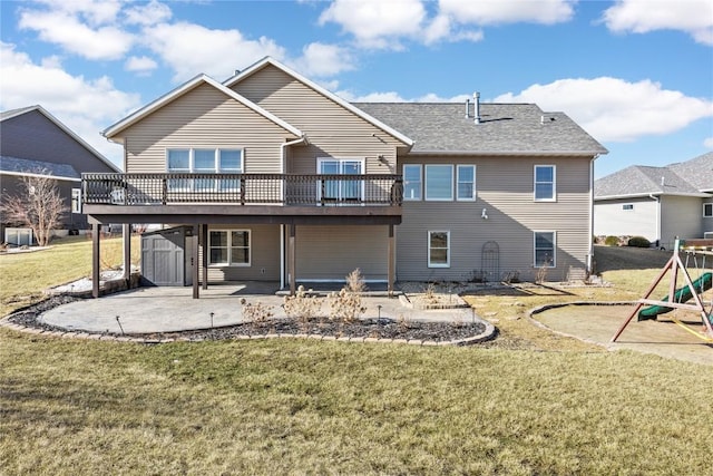 rear view of house with a yard, a playground, a wooden deck, and a patio area