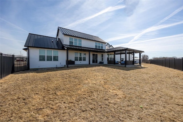 back of house with a patio area, a fenced backyard, metal roof, and a standing seam roof