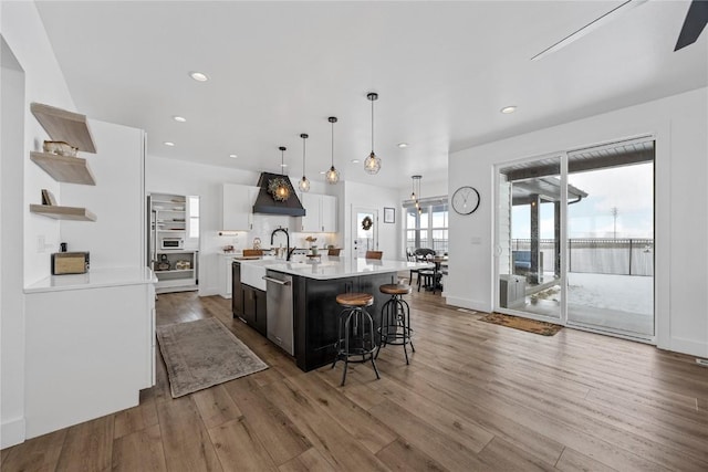 kitchen featuring wood finished floors, open shelves, light countertops, white cabinets, and dishwasher