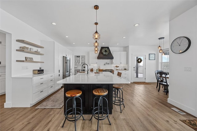 kitchen with open shelves, high end fridge, white cabinets, and light countertops