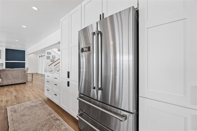 kitchen with white cabinets, recessed lighting, wood finished floors, and high end fridge