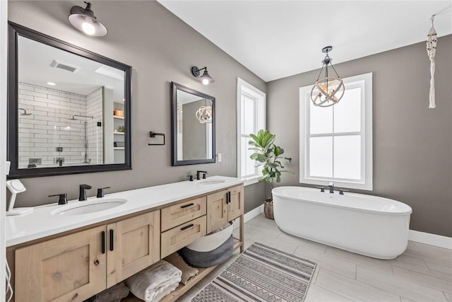 bathroom with a soaking tub, visible vents, a shower stall, and a sink