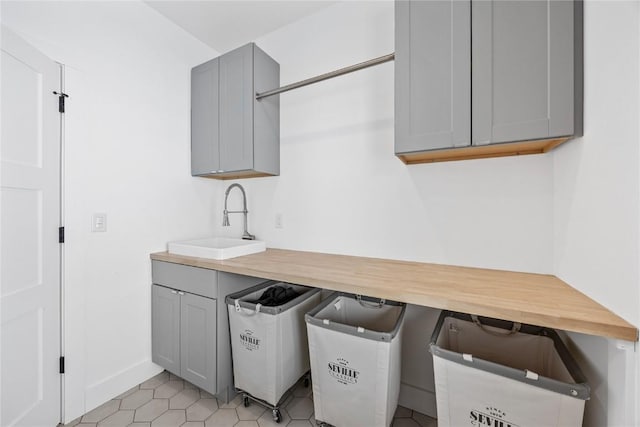 laundry room featuring a sink and light tile patterned floors