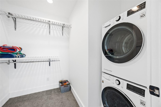 laundry room with laundry area, carpet flooring, stacked washer / drying machine, and baseboards