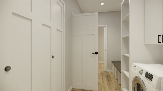 clothes washing area featuring light wood-style flooring, washer / clothes dryer, cabinet space, and recessed lighting