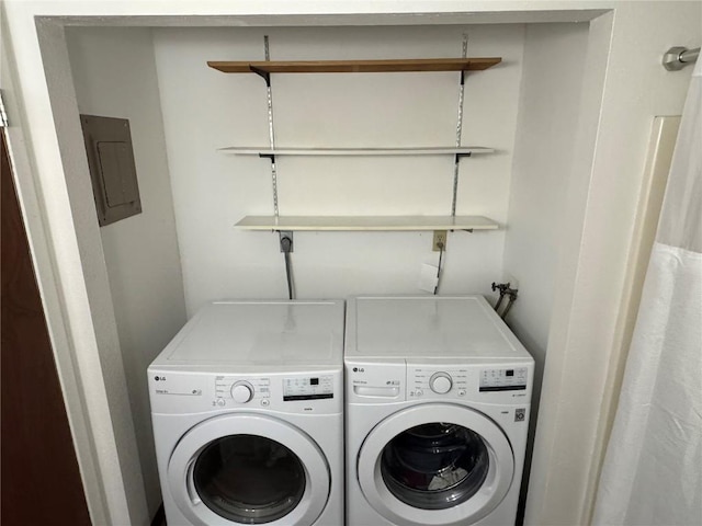 clothes washing area with laundry area, electric panel, and washer and clothes dryer