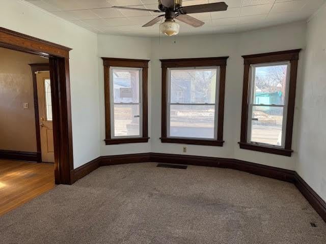 empty room featuring visible vents, baseboards, and carpet