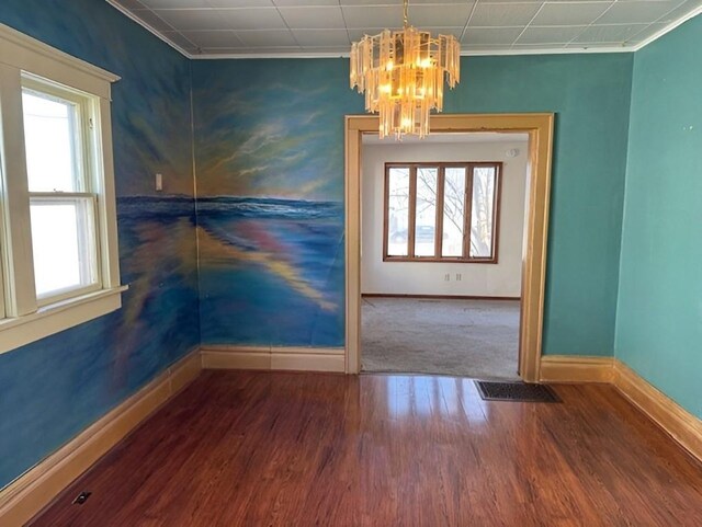 609 Baltimore St, Waterloo, IA 50702 - unfurnished room with plenty of natural light, baseboards, an inviting chandelier, and wood finished floors