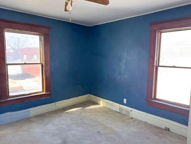 609 Baltimore St, Waterloo, IA 50702 - spare room featuring a wealth of natural light, baseboards, ceiling fan, and carpet floors