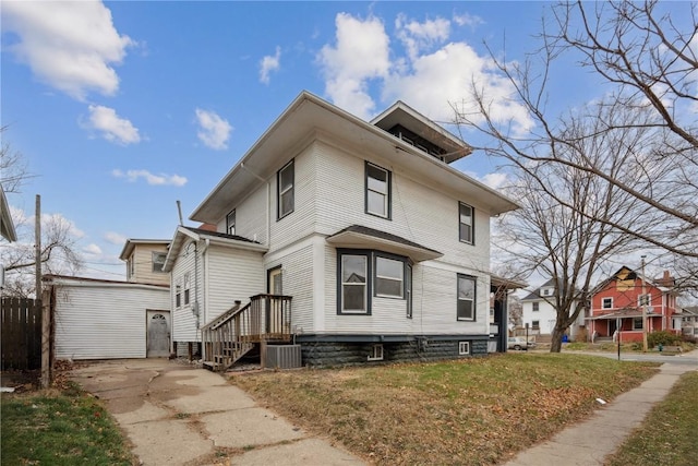 view of front facade with central AC unit, a front yard, and an outdoor structure