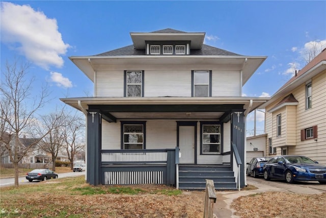 traditional style home with a porch and a shingled roof