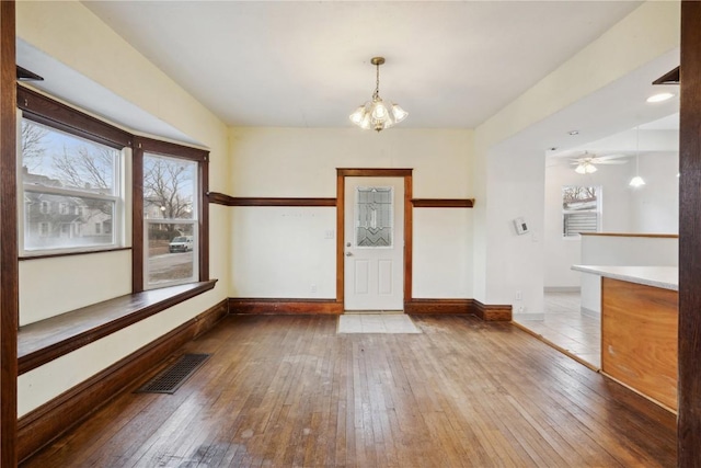 entryway featuring a notable chandelier, visible vents, baseboards, and wood-type flooring