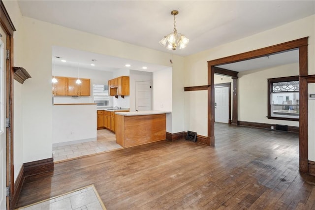 kitchen featuring hanging light fixtures, hardwood / wood-style flooring, a notable chandelier, and light countertops