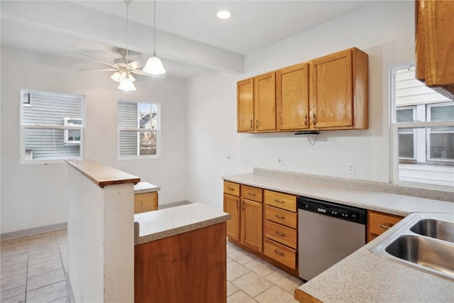 kitchen featuring stainless steel dishwasher, light countertops, brown cabinetry, and a sink