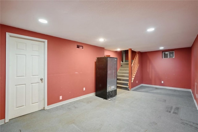 finished basement with recessed lighting, light colored carpet, stairs, and baseboards