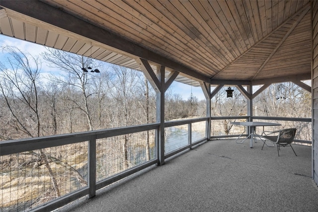 unfurnished sunroom featuring wood ceiling and lofted ceiling