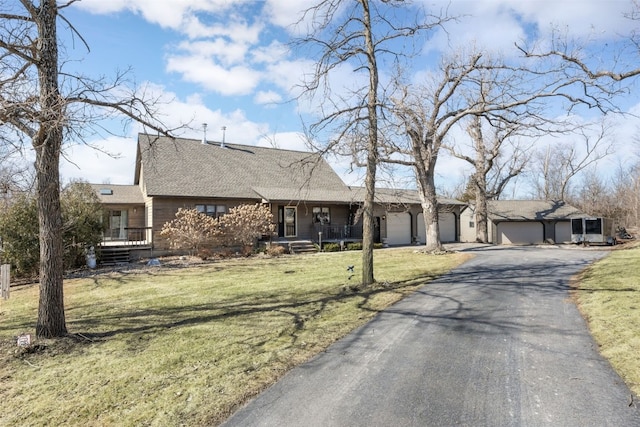 view of front of house with driveway, a front lawn, a porch, and an attached garage