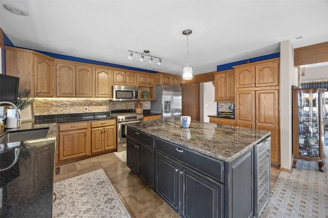 kitchen with backsplash, a kitchen island, wine cooler, appliances with stainless steel finishes, and a sink