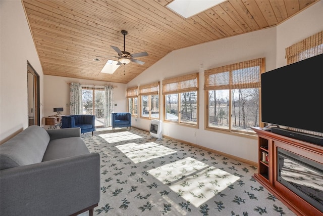 living area with lofted ceiling with skylight, heating unit, carpet floors, baseboards, and wood ceiling