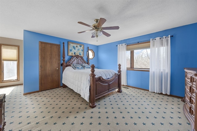 carpeted bedroom with a ceiling fan, baseboards, and a textured ceiling