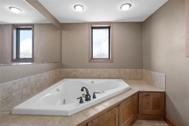 full bathroom featuring a tub with jets and a textured ceiling