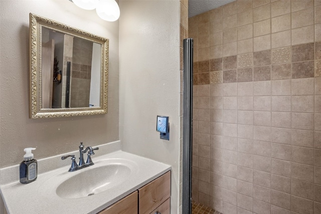 bathroom featuring a tile shower and vanity