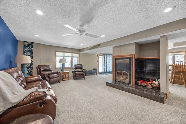 living area featuring a textured ceiling, recessed lighting, carpet, a fireplace, and ceiling fan