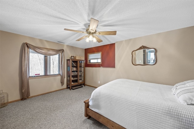 bedroom featuring a ceiling fan, baseboards, a textured ceiling, and carpet flooring