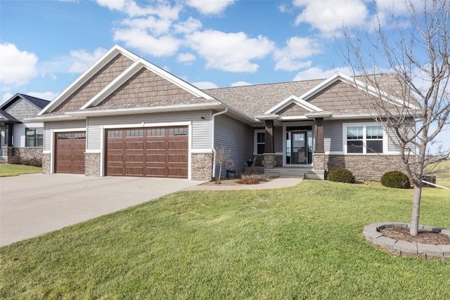 craftsman house with a front yard, a garage, stone siding, and driveway