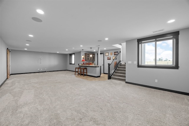 below grade area with recessed lighting, visible vents, light colored carpet, and stairs