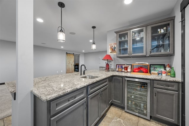 kitchen featuring beverage cooler, a peninsula, recessed lighting, a sink, and a barn door