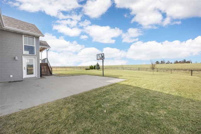 view of yard with a rural view, a patio, and a fenced backyard