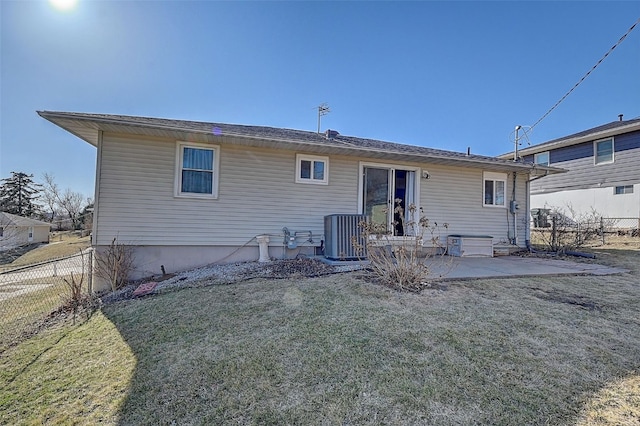 rear view of house featuring a patio area, a yard, fence, and central AC