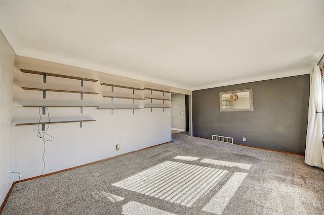 empty room featuring carpet flooring, baseboards, and visible vents