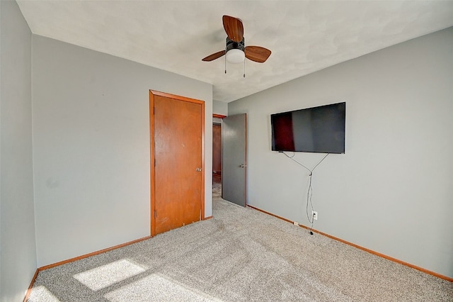 interior space featuring baseboards, carpet floors, and a ceiling fan