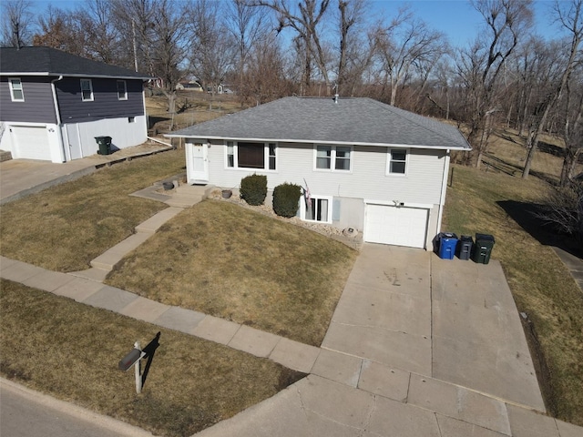 view of front of house featuring a garage, driveway, a shingled roof, and a front yard