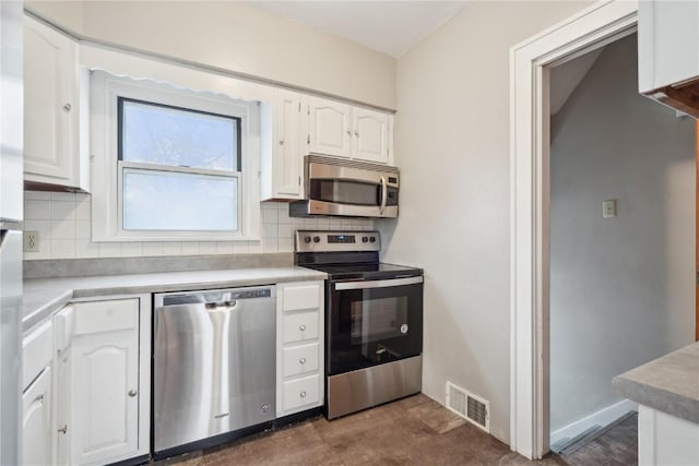 kitchen featuring white cabinetry, decorative backsplash, visible vents, and stainless steel appliances