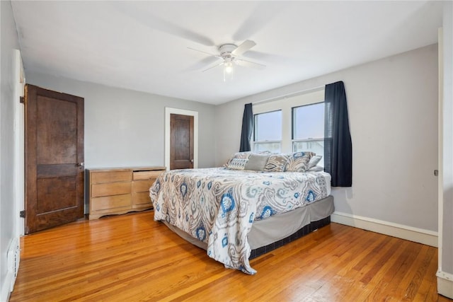 bedroom featuring baseboards, light wood-style flooring, and a ceiling fan