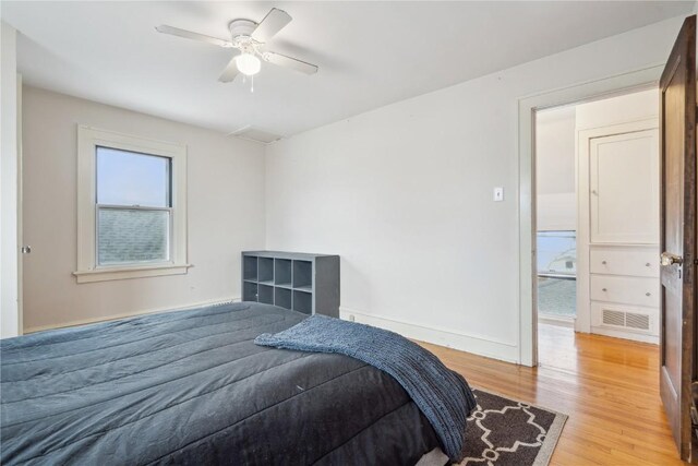 bedroom with baseboards, light wood-type flooring, and ceiling fan