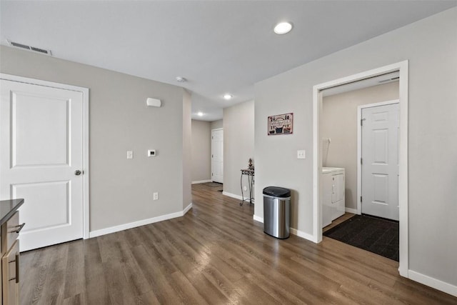 unfurnished room with visible vents, baseboards, recessed lighting, wood finished floors, and washer and dryer