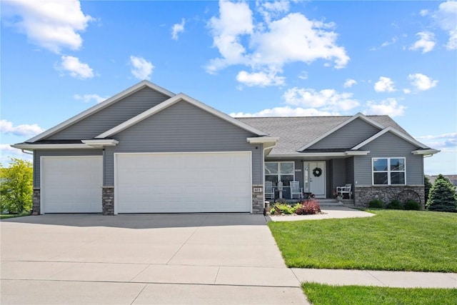 view of front of house with driveway, stone siding, a front yard, and an attached garage