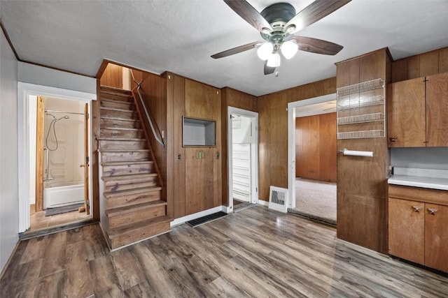 interior space featuring visible vents, wooden walls, wood finished floors, and stairs